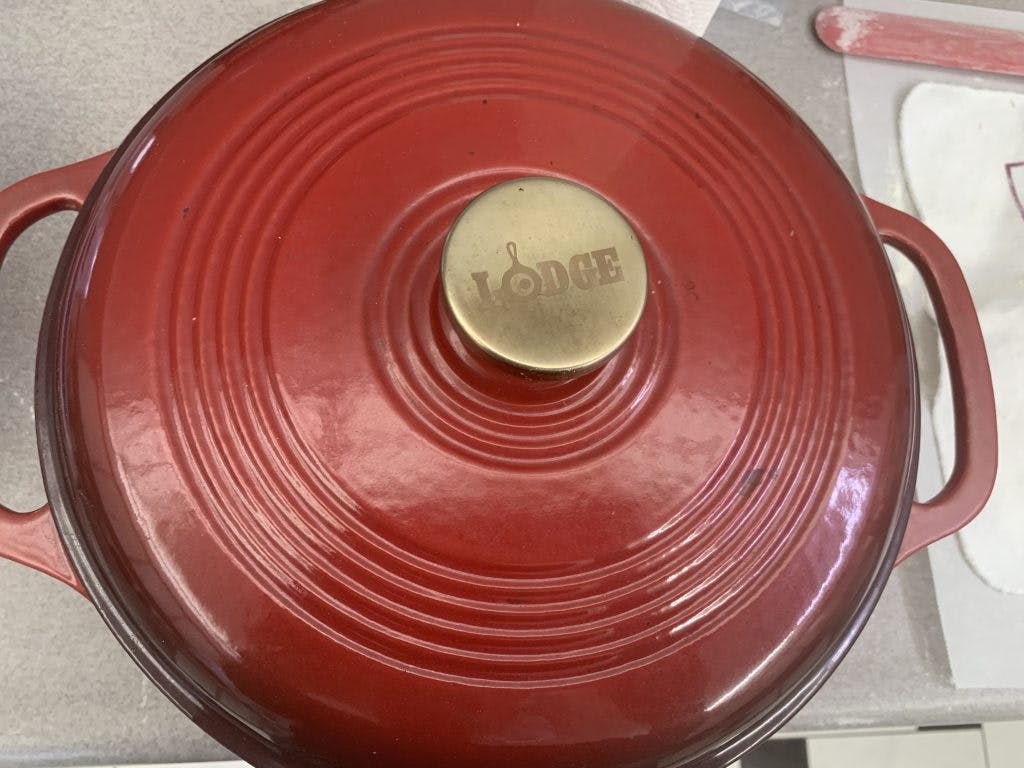 A Cast Iron Dutch oven with "Lodge" written on the lid.