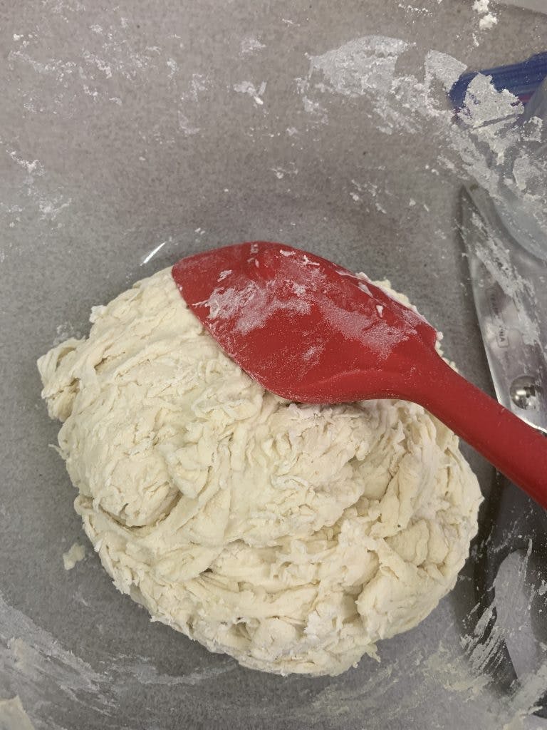 Bowl of flour being mixed into dough.
